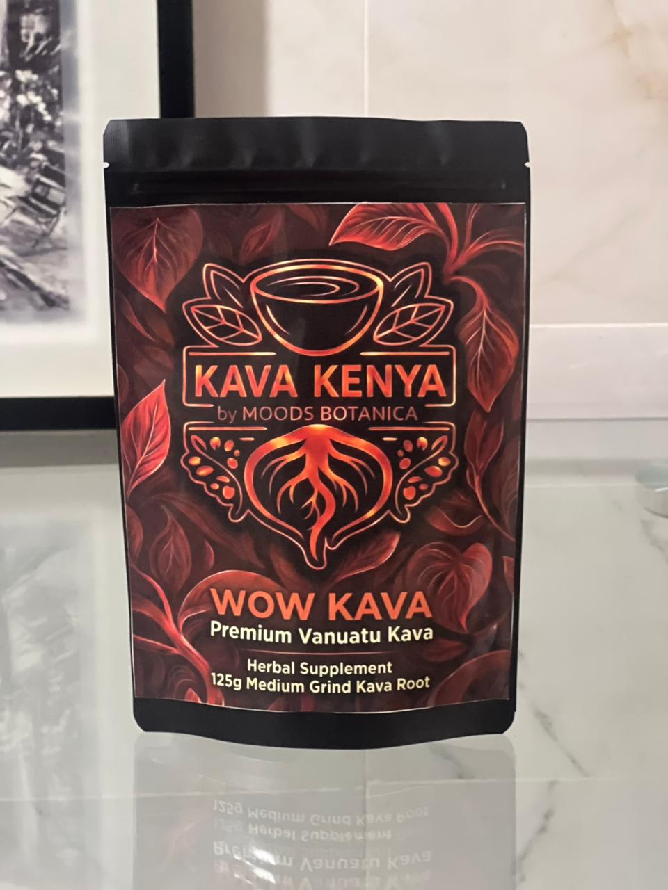 Wow Kava Kenya packaging on a reflective surface with a blurred background